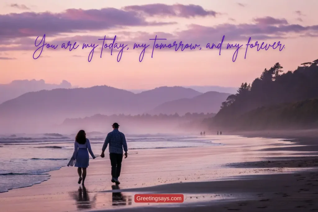 Beach couple image: A couple walking hand in hand along a serene beach during sunset, with waves gently lapping at the shore and misty mountains in the background. The quote reads, "You are my today, my tomorrow, and my forever."